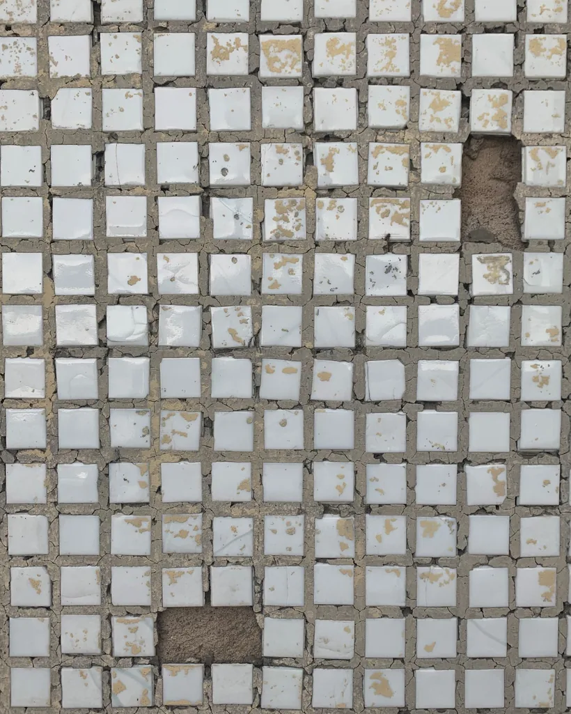 Detalle de un mosaico antiguo con teselas desgastadas y algunas piezas ausentes